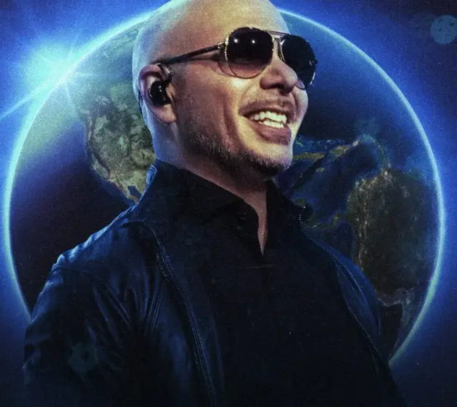 Pitbull w okularach przeciwsłonecznych uśmiecha się na tle Ziemi. To zapowiedź jego światowego koncertu.