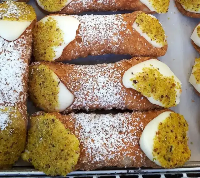 Chrupiące rurki wypełnione kremem i posypane pistacjami. Te pyszne **cannoli** wyglądają jak dzieła sztuki cukierniczej.