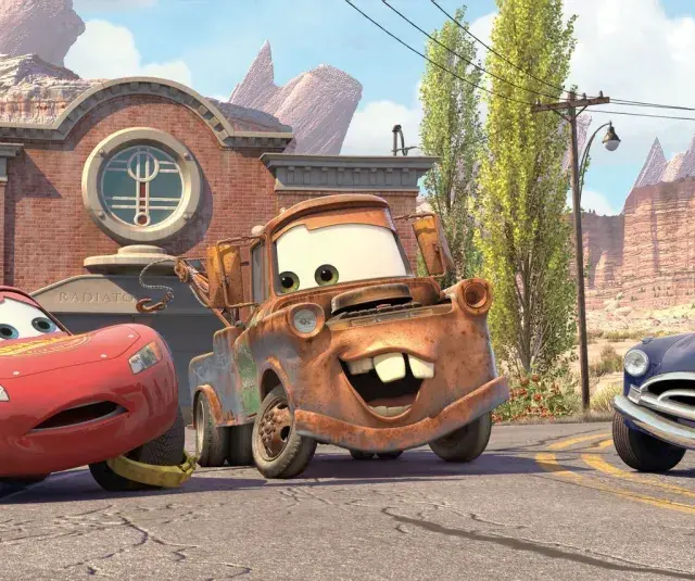 Zabawne auta z bajki: Zygzak McQueen, Złomek i Doc Hudson na tle Route 66.
