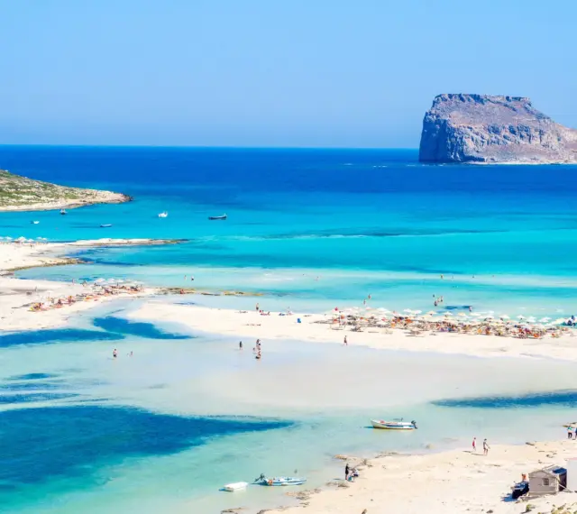 Piękna plaża z turkusową wodą i skalistą wysepką. Czy to Rodos czy Kreta?