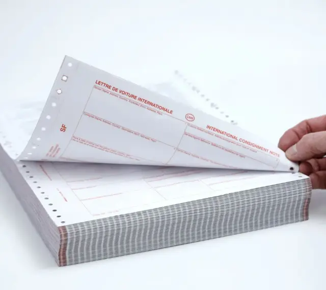 Stos papierów z nadrukiem "CMR" i "INTERNATIONAL CONSIGNMENT NOTE". Dokumenty te służą do międzynarodowego przewozu towarów.