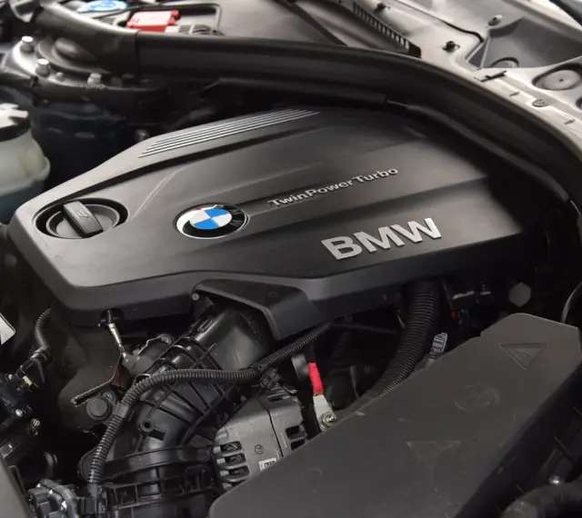 Silnik BMW TwinPower Turbo, prawdopodobnie 2.0 diesel, z widocznym logo BMW i elementami osprzętu.