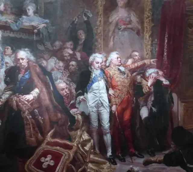 Tadeusz z obrazu Matejki, leżący na ziemi, z uniesioną głową i ręką na piersi, w otoczeniu innych postaci.
