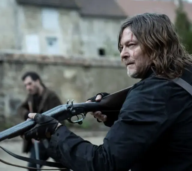 Daryl Dixon z sezonu 3, z blizną na twarzy, celuje z dwururki. W tle inny mężczyzna.