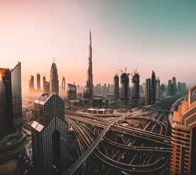 Zachód słońca nad Dubajem, z drapaczami chmur i skomplikowanymi węzłami drogowymi. Czy w Dubaju jest bezpiecznie? Tak, to nowoczesne miasto oferuje spokój.