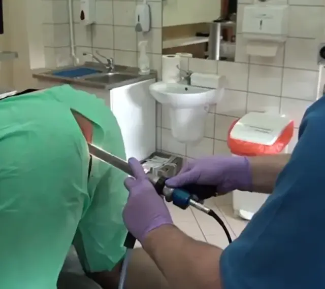 Lekarz w rękawiczkach wykonuje badanie jelit za pomocą endoskopu.