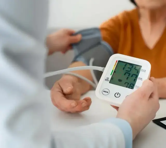 Pomiar ciśnienia krwi. Na ekranie aparatu widnieje wynik 134/77, a poniżej 78.
