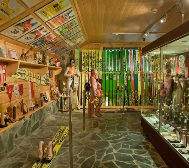 Wnętrze muzeum Adama Małysza w Wiśle. W gablotach i na półkach wyeksponowano medale, puchary, narty i kombinezony skoczka.