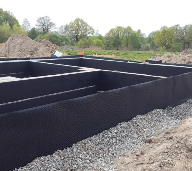 Fundament gotowy do zalania betonem. Czarna folia izolacja pozioma chroni przed wilgocią.
