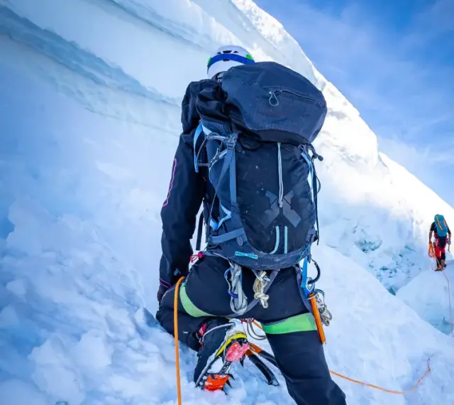 Wspinaczka na szczyt w Himalajach. Dwóch alpinistów wspinających się po lodowej ścianie, wspinaczka na szczyt w Himalajach.