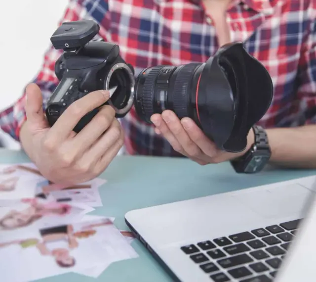 Fotograf przygotowuje sprzęt. Zastanawia się, czy robienie zdjęć z ukrycia jest karalne, przeglądając wydrukowane fotografie.