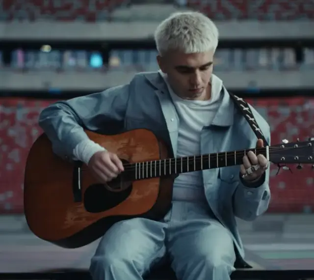 Mata gra na gitarze w pustym stadionie, zapowiadając swój nowy album.