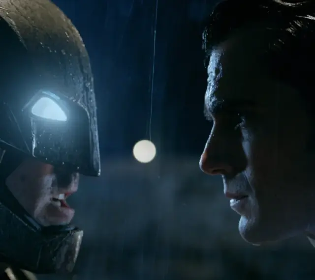 Batman w zbroi i Superman w deszczu, twarz w twarz. Napięcie przed walką Batman vs Superman.