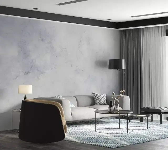 Nowoczesny salon z sofą, stolikami i dywanem. Ściana za sofą ma subtelny **efekt betonu**, nadając wnętrzu industrialny charakter.