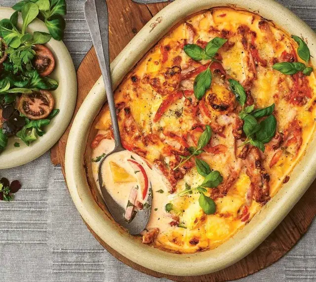 En krämig kasslergratäng med ost och örter, serverad med en fräsch sallad. Ett perfekt kassler recept för middagen.