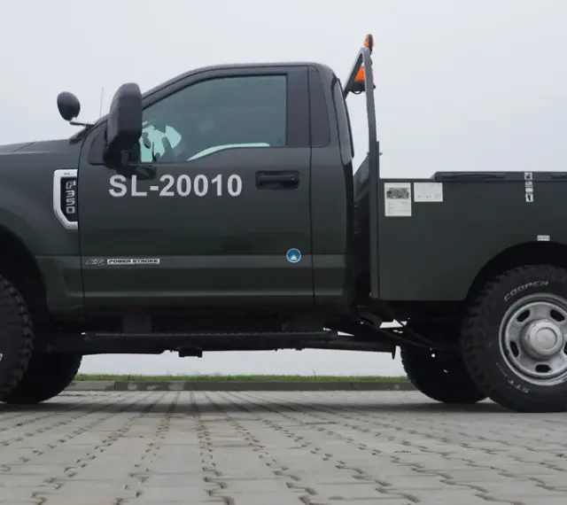 Ciemnozielony Ford F350 z zabudową typu "flatbed" i numerem SL-20010. Solidna maszyna gotowa do pracy.