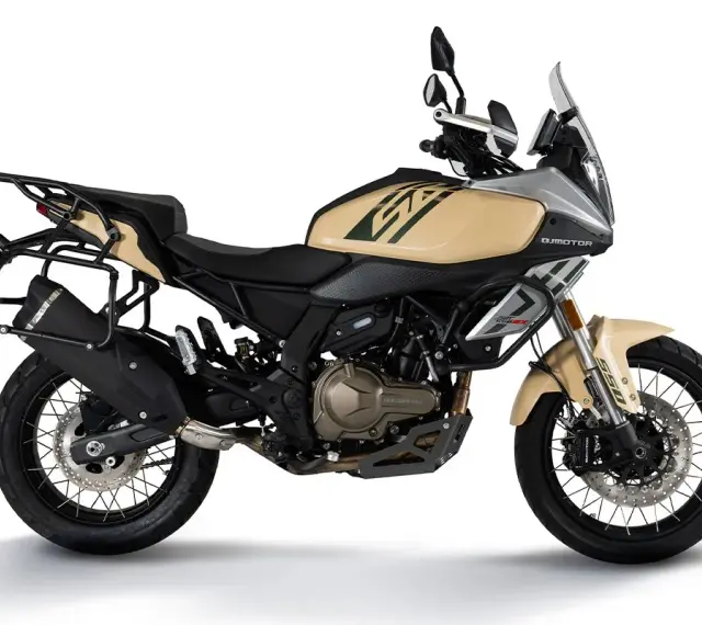 Beżowy motocykl turystyczny z bagażnikami, gotowy na dalekie wyprawy.