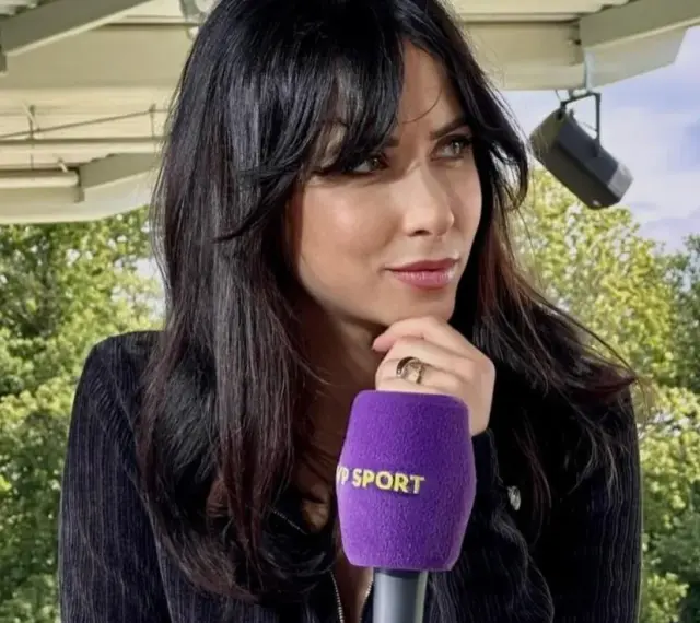 Maja Strzelczyk z mikrofonem Polsat Sport, w otoczeniu zieleni, przygotowuje się do wywiadu.