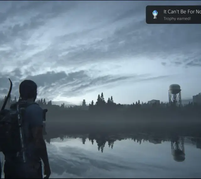 Joel mira un lago tranquilo, con un cartel de "Platino The Last of Us Parte 1" flotando.