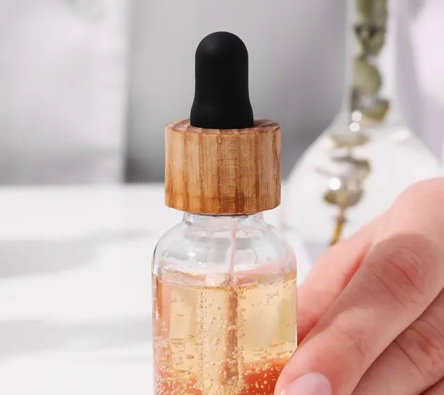 Dłoń trzymająca serum z pipetką. Składniki takie jak EDTA w kosmetykach pomagają stabilizować formuły.
