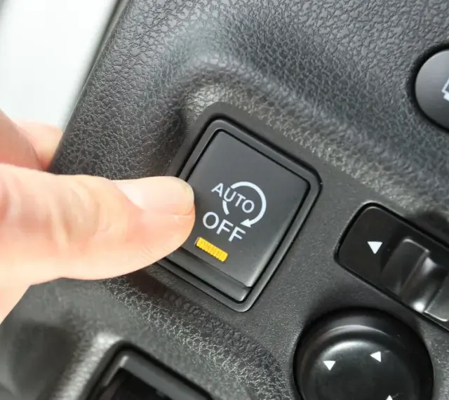 Palec naciska przycisk "AUTO OFF", wyłączając system start-stop.