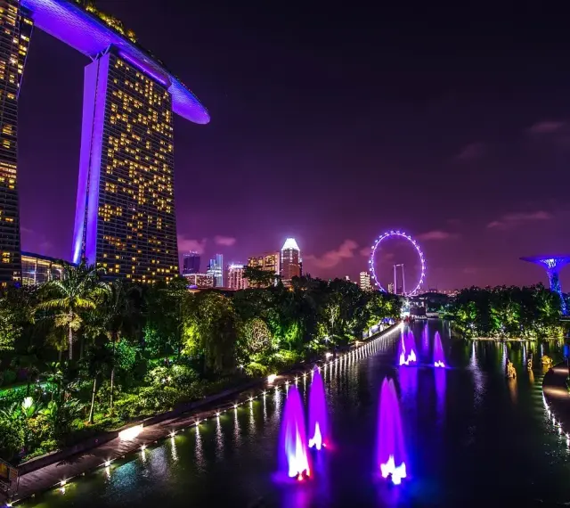 Nocny Singapur z Marina Bay Sands, diabelskim młynem i świetlistymi drzewami. Marzenie o wizie do Singapuru staje się rzeczywistością.