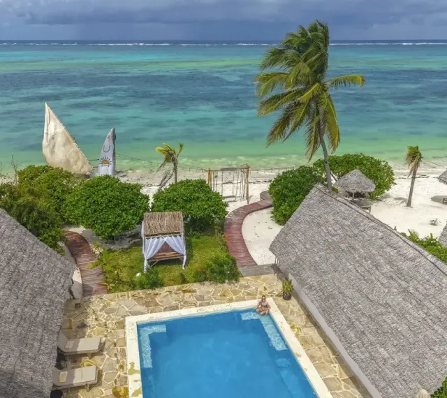 Zanzibar w lutym: słoneczna pogoda, turkusowe morze, palmy i urocze domki z krytymi dachami. Idealne miejsce na relaks.