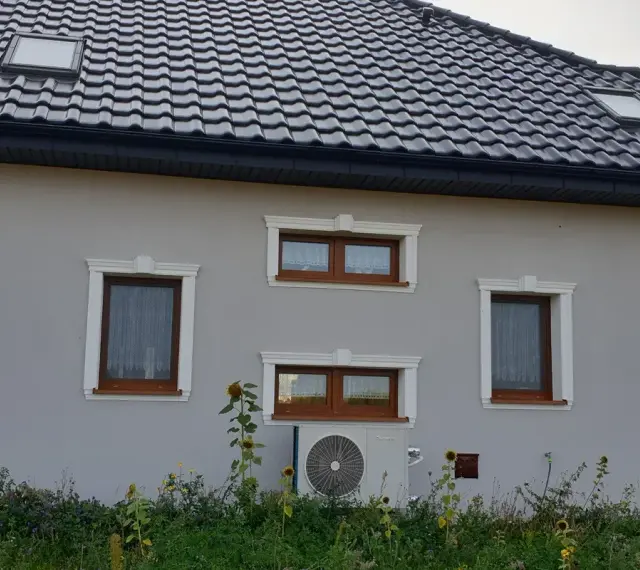 Elegancki gzyms zdobi okna domu, nadając mu stylowy wygląd.