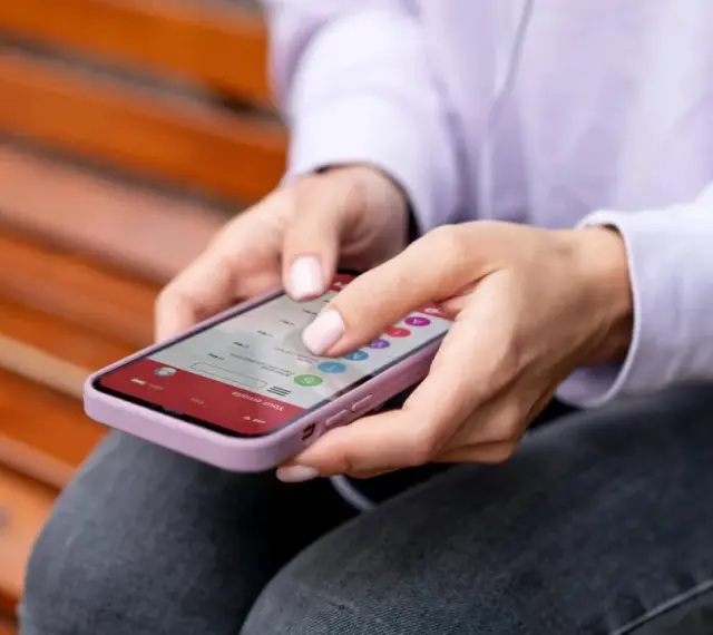 Dłonie kobiety obsługują smartfon, czując subtelne wibracje haptyczne przy każdym dotknięciu ekranu.