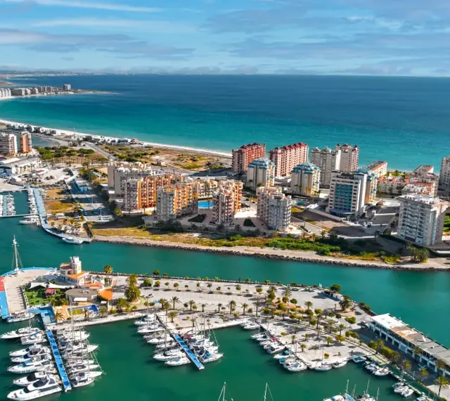 Widok na la Manga, Hiszpania: luksusowe apartamenty i pełen jachtów port nad turkusowym morzem.