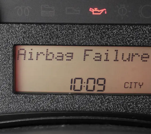 Na desce rozdzielczej świeci się kontrolka poduszki powietrznej z napisem "Airbag Failure". Obok widnieje godzina 10:09 i napis CITY.
