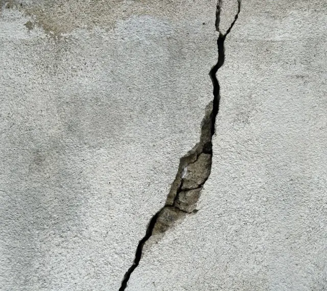 Pęknięcie na betonowej ścianie, które może wskazywać na ukryte przyczyny pękania ścian w blokach oddanych do użytku po 2024 roku.