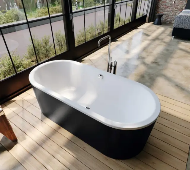Vasca da bagno freestanding nera e bianca, con rubinetteria a colonna. L'altezza della vasca da bagno in muratura è ideale per un bagno moderno.
