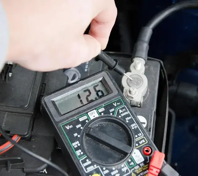 Pomiar napięcia akumulatora multimetrem. Wynik 12.6V wskazuje na dobry stan.