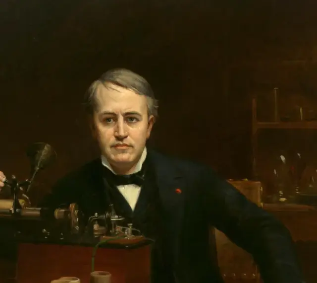 Porträt von Thomas Edison, der an einem Phonographen arbeitet. Er ist der Mann, der die Glühbirne erfunden hat.
