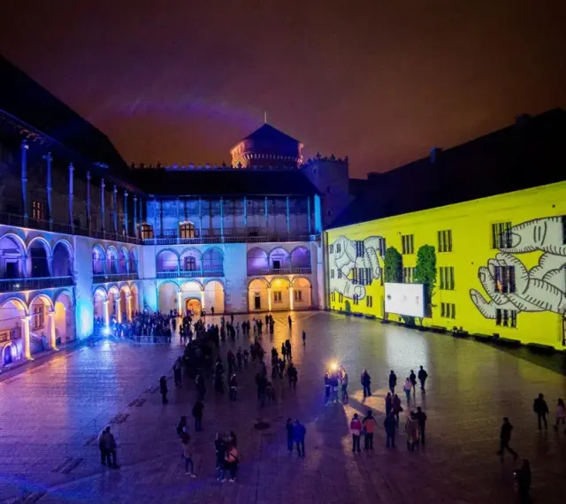 Nocne iluminacje na dziedzińcu zamkowym, przypominające o bogactwie muzeów w Polsce.