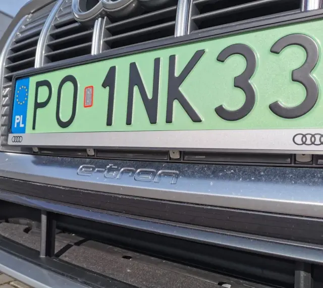 Zielone tablice rejestracyjne z numerem PO 1NK33 na samochodzie Audi e-tron.