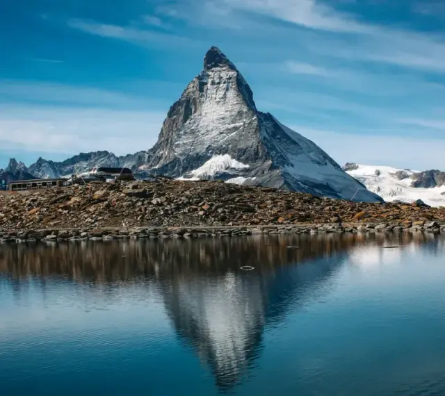 Majestatyczny Matterhorn odbija się w spokojnym jeziorze. Czy Szwajcaria jest w Schengen? Tak, podróżni mogą swobodnie przekraczać granice.