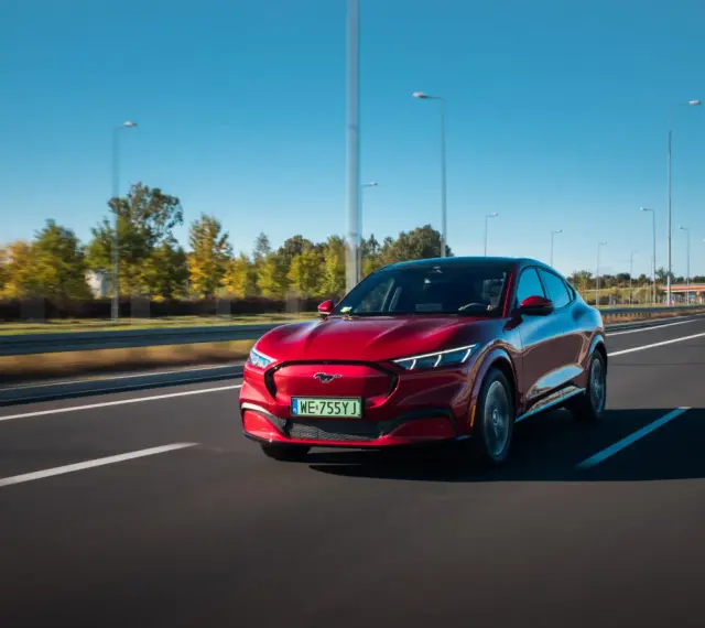 Czerwony Ford Mustang Mach-E jedzie po autostradzie w Polsce.