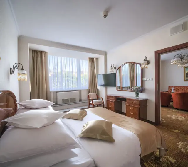 Przytulny pokój hotelowy w Białymstoku z wygodnym łóżkiem, toaletką i widokiem na salon.
