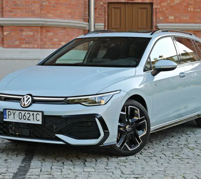 Jasny VW Golf 8 Variant na brukowanej ulicy przed ceglanym budynkiem. Elegancki kombi z nowoczesnym designem.