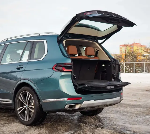 Zielony BMW X7 z otwartym bagażnikiem, idealny na rodzinne wyjazdy. Sprawdź aktualną bmw x7 cena.
