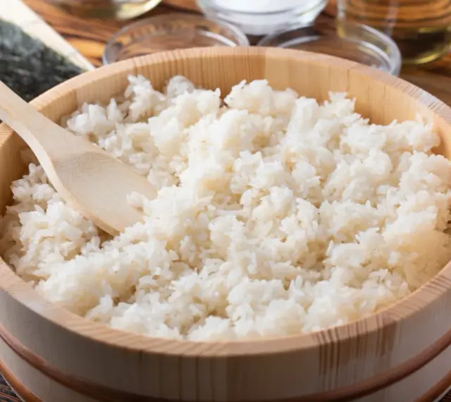 Gotowy ryż do sushi w drewnianym naczyniu, z widoczną drewnianą łopatką. Idealne proporcje dla każdego miłośnika japońskiej kuchni.