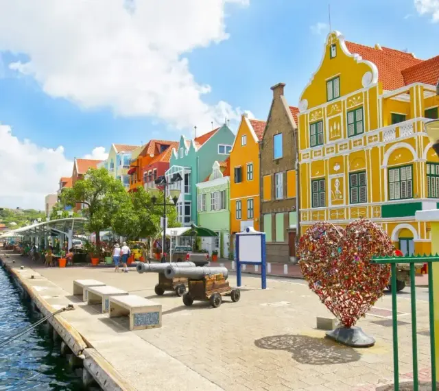 Kolorowe budynki, port i serce z kłódek – idealne miejsce na curacao wakacje.