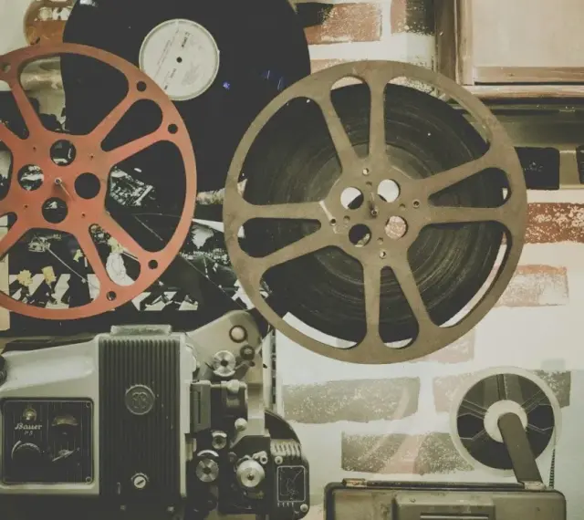 Stare klisze filmowe i projektor, gotowe do odtworzenia historii pełnej emocji i dramatów.