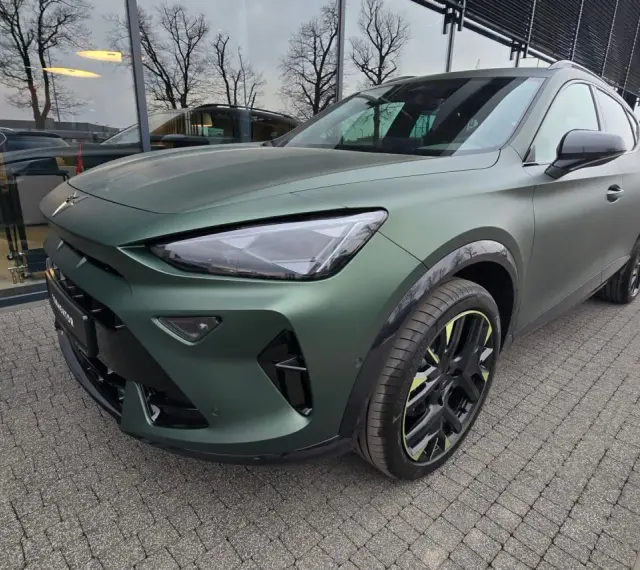 Nowa Cupra w matowym, zielonym kolorze prezentuje się imponująco na tle salonu.