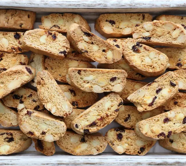 Un vassoio pieno di croccanti biscotti toscani, ricchi di mandorle e mirtilli rossi, pronti per essere inzuppati.