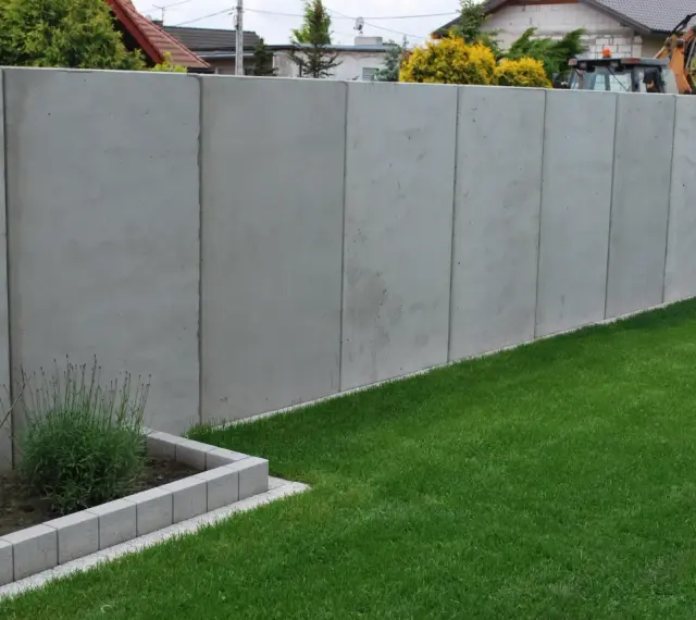 Betonowy mur wysoki na 2,2m. Unikaj najgorszych błędów przy zgłaszaniu budowy ogrodzenia powyżej 2,2 metra po nowym prawie.