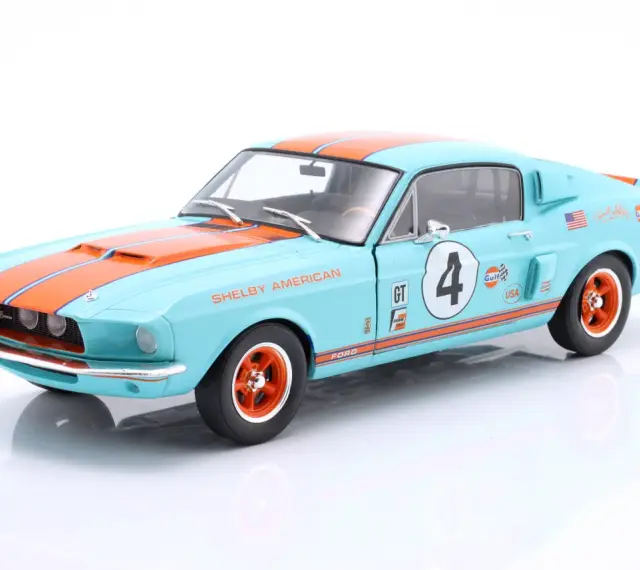 Błękitny Shelby GT z pomarańczowymi pasami i numerem 4, ozdobiony logotypami Gulf i USA.