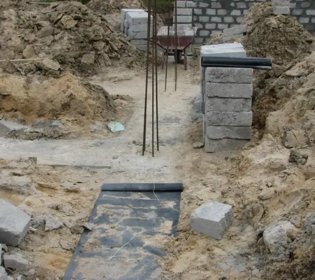 Budowa domu. Kopanie pod fundamenty, zbrojenie i pierwsze warstwy bloczków betonowych.